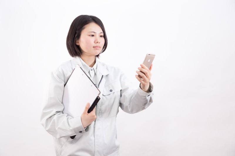 スマホを見る女性作業員