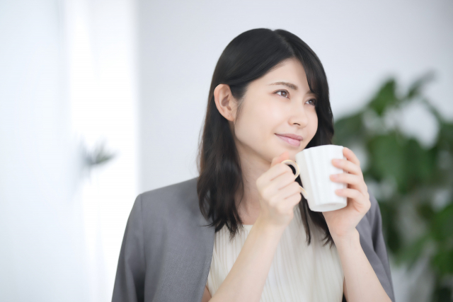 コーヒーカップを持つ女性
