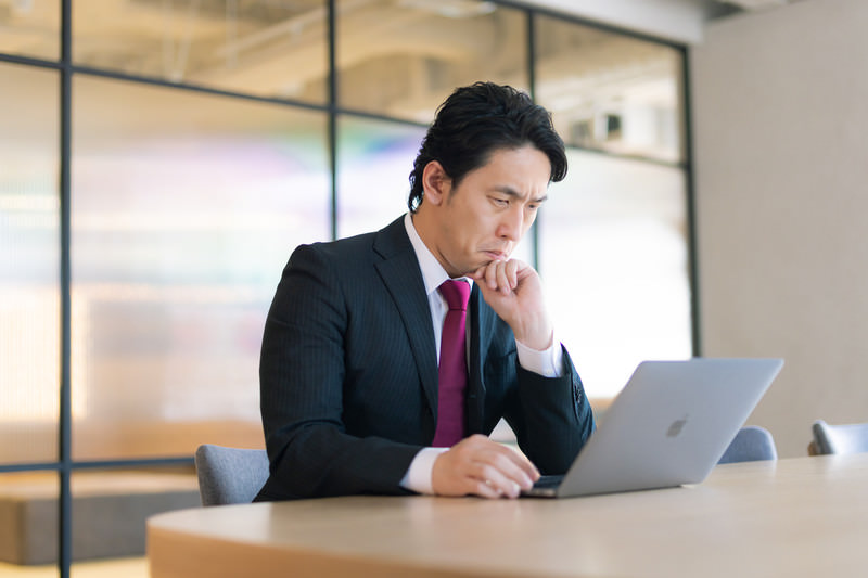 スーツの男性がパソコンに向かう