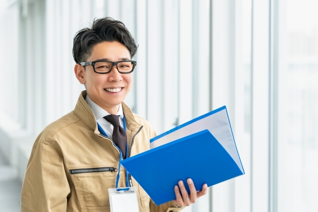 ファイルを持ったメガネの男性