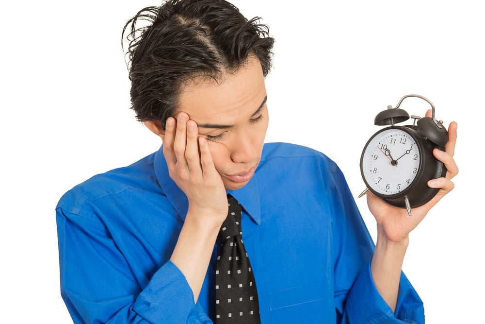 Portrait sleeping young man holding alarm clock isolated on white background. Long working hours, lack of sleep, sleep deprivation, no motivation concept. Face expression-1